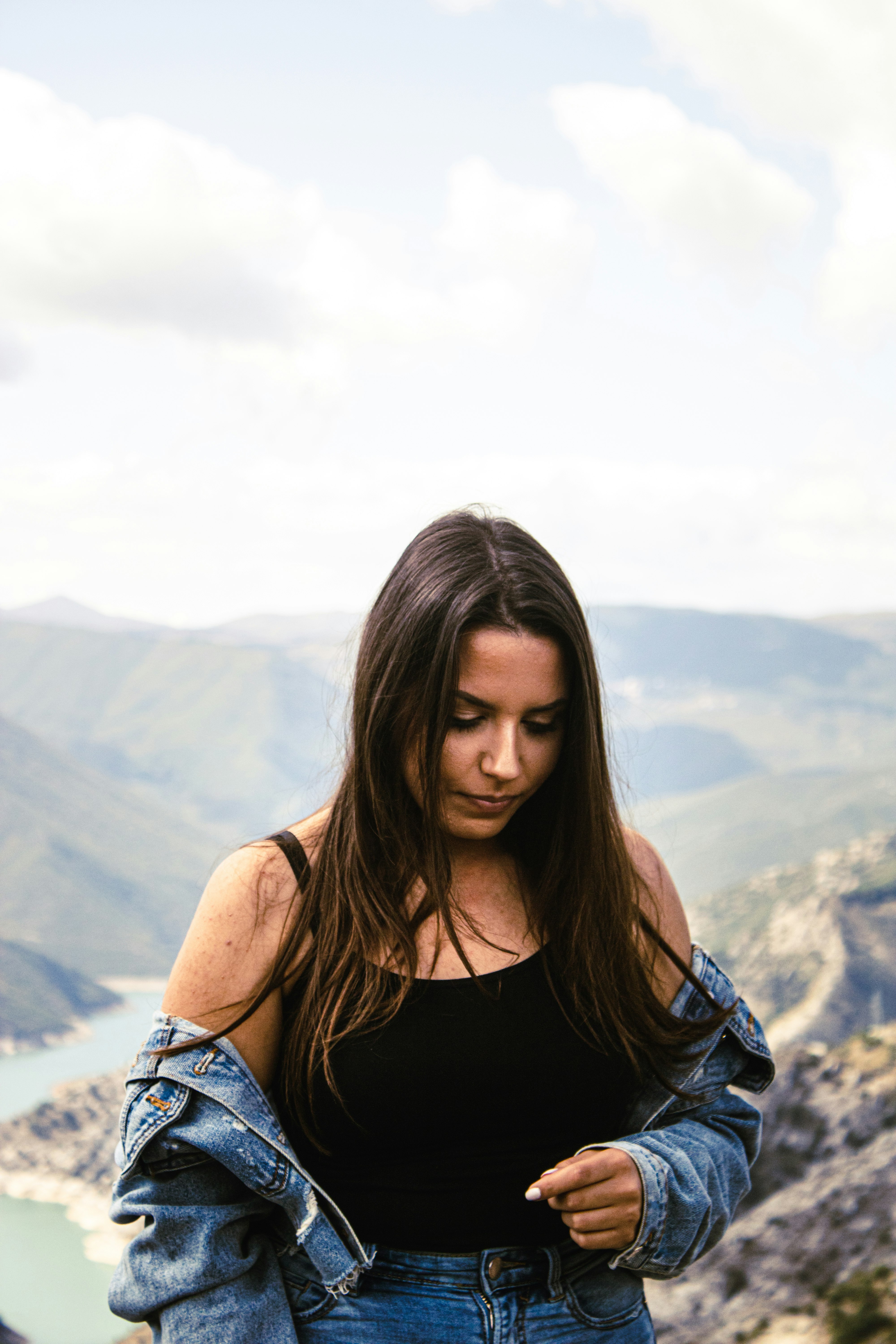 woman in black tank top standing on top of mountain during daytime